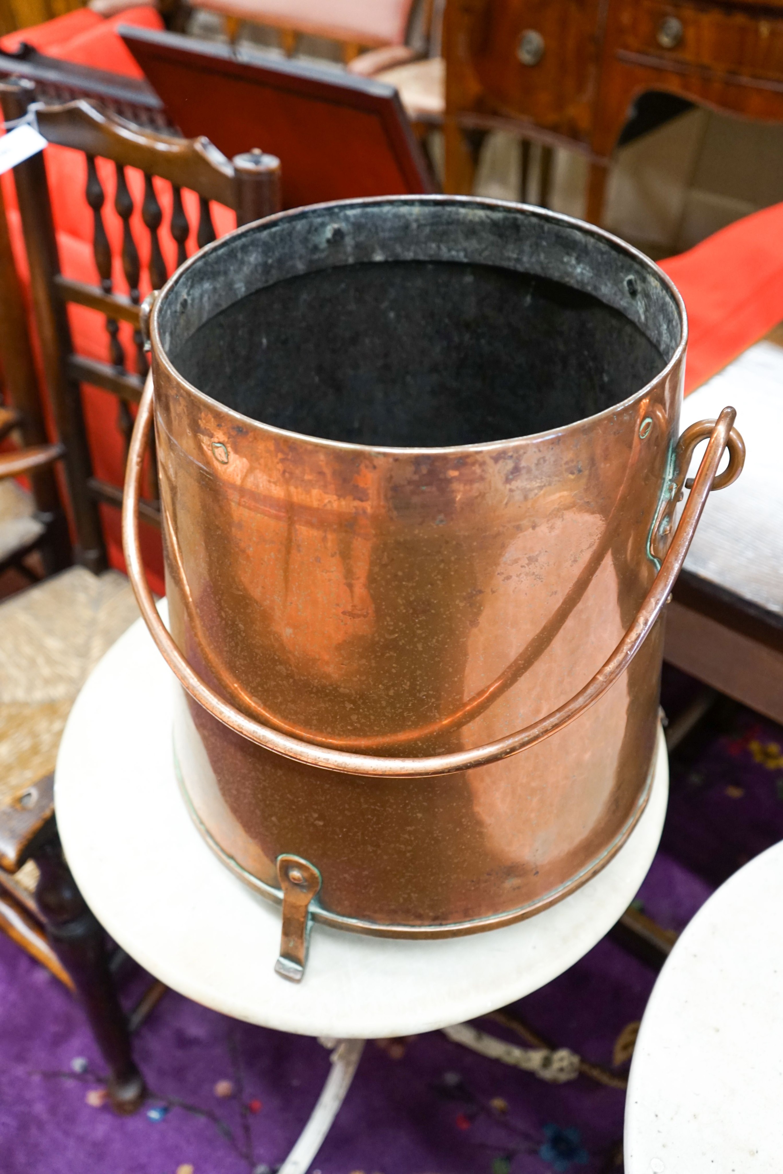A Dutch copper milk churn and cover, having brass knop finial and swing handle on three feet, height 55cm